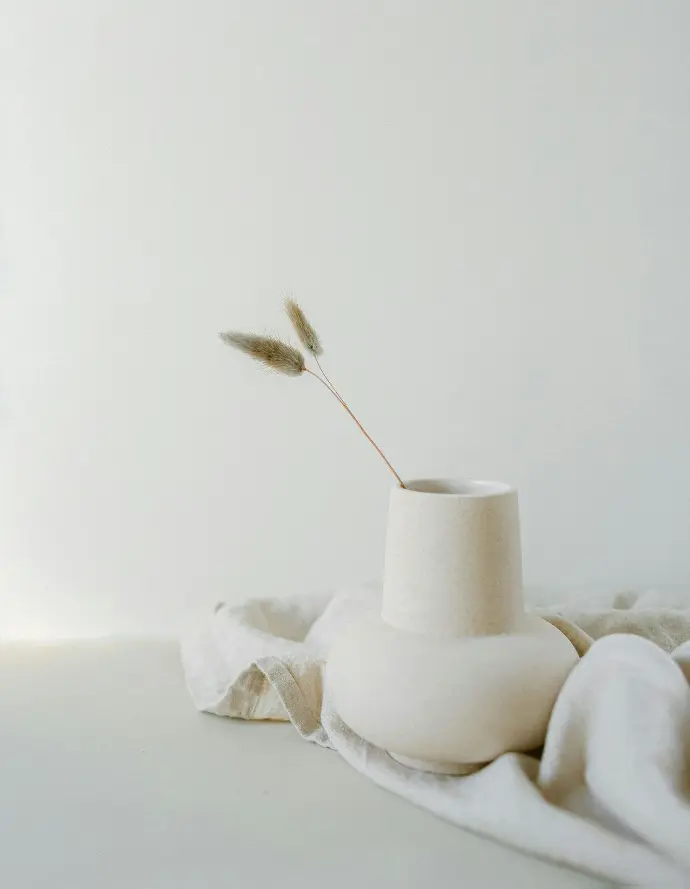 a white vase sitting on top of a white table